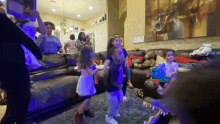 a group of children are dancing in a living room with a crocodile in the foreground