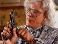 a woman is holding a gun in her hand .