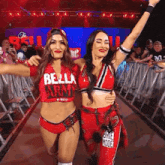 two female wrestlers wearing red outfits with bella army written on them