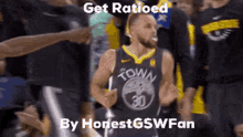 a basketball player wearing a golden state warriors jersey is running in front of a crowd of people .