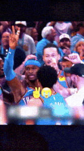 a basketball player giving a peace sign in front of a crowd of fans
