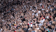 a crowd of people in a stadium with one wearing a shirt that says ' a ' on the front