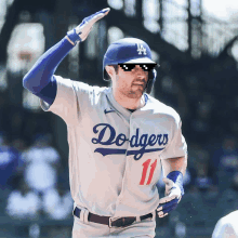 a dodgers player wearing sunglasses and a helmet runs on the field