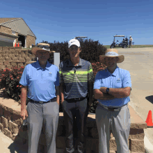 three men are posing for a picture with one wearing a shirt that says visa