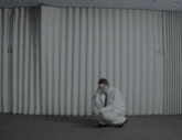 a man is sitting on the floor with his head down