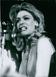 a black and white photo of a woman singing into a microphone with her mouth open