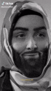 a black and white photo of a man with a beard and a scarf around his head with tiktok written on the bottom