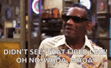 a man wearing sunglasses and a shirt is standing in a store and talking .
