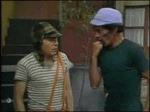 two men wearing striped shirts and hats are standing next to each other and talking .