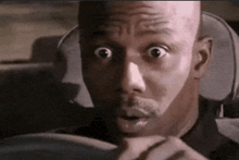 a man with a surprised look on his face while driving a car