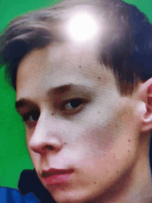 a close up of a young man 's face with a light shining on his head