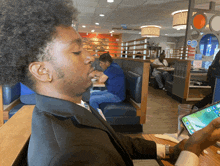 a man sitting at a table looking at his phone