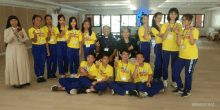 a group of people posing for a picture with one wearing a yellow shirt that says prayer