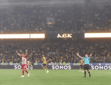 a soccer game is being played in front of a sign that says sonos