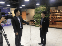 a man in a suit is talking into a microphone in front of a sign that says vietnet net