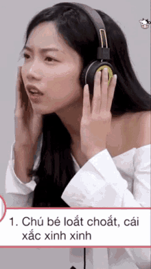 a woman wearing headphones and a white shirt is making a funny face .