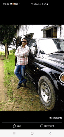 a man standing next to a black car with the time 03:43 on the bottom