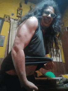 a man with long hair is wearing sunglasses and a tank top