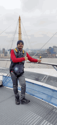 a man standing on top of a building with a thumbs up