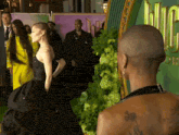 a woman in a black dress stands next to a man with a shaved head in front of a sign that says mcdonalds