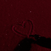 a heart is drawn in the snow on a red background