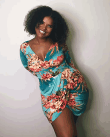 a woman wearing a blue floral dress is smiling