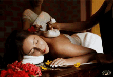 a woman is getting a massage in a spa with a bag of herbs on her back .