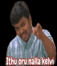 a man in a plaid shirt is pointing at the camera with the words `` ithu oru nilla kelvi '' .