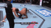 two men are fighting in a boxing ring with a bud light advertisement in the background