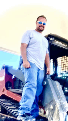 a man wearing sunglasses stands next to a machine that says 140