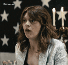 a woman is sitting in front of an american flag with the words brownunit written on the bottom