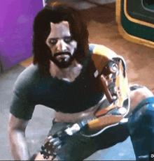 a man with a beard and a robotic arm is sitting on the floor .