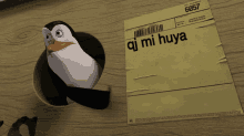 a penguin is sticking its head out of a hole next to a piece of paper that says oj mi hua