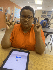 a person sitting at a table with a tablet that says ' i 'm sorry ' on it