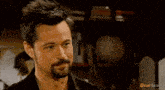 a man and a woman are looking at each other in a room .