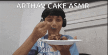 a boy wearing headphones is eating cake with a spoon and the caption arthav cake asmr