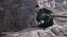 a poster for running wild with bear grylls shows a woman on a rock