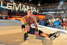 a man is sitting on the ground in front of a crowd .