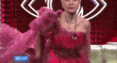 a woman in a pink dress is sitting on a couch in front of an eye .