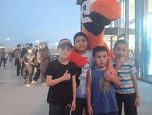 a group of young boys pose with a mascot wearing a shirt that says emirates