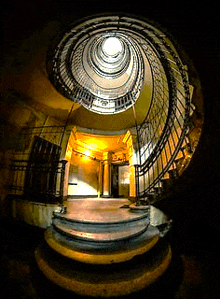 a spiral staircase with a light shining through the top