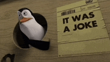 a penguin is sticking its head out of a hole in a piece of paper that says it was a joke