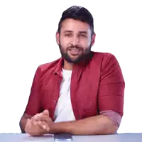a man in a red shirt is sitting at a table