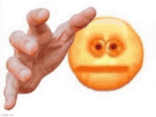 a hand is reaching out towards a yellow smiley face with big eyes .