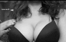 a woman 's breasts are shown in a black and white photo with the words love me written on the bottom .