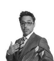 a man wearing glasses and a suit holds up his hand