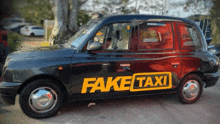 a black taxi with fake taxi written on it