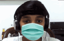 a young boy wearing headphones and a mask on his face