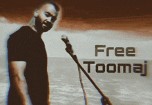 a man singing into a microphone with the words free toomaj written below him