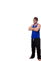 a man in a blue tank top is standing with his arms crossed